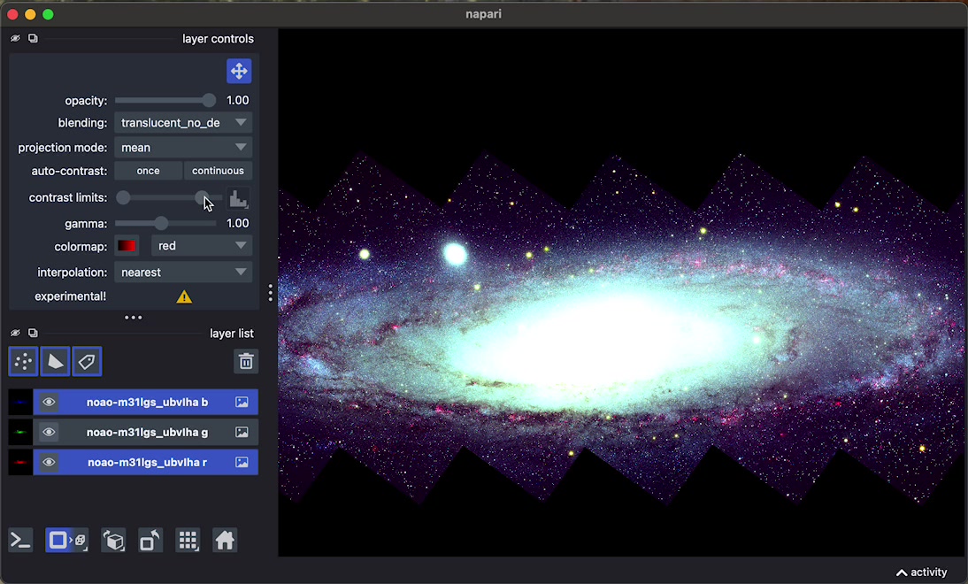video of a napari viewer showing an image of a galaxy. The red and
      blue color channels get adjusted together by selecting them on the layer
      list and ajusting the parameters.